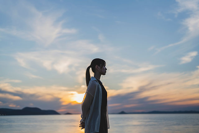 海を背景にする女性