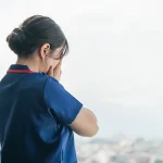 屋上で泣く看護師