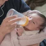ミルクを飲ませる助産師