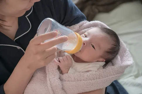 ミルクを飲ませる助産師