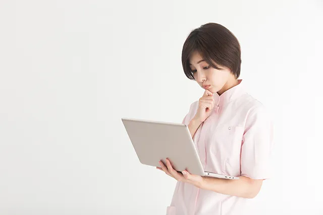 パソコンを手に悩む看護師