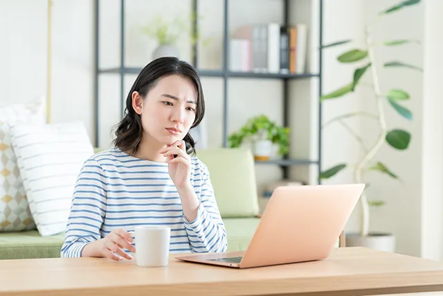 パソコンを見て悩む女性