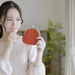 財布を見て渋い顔をる女性