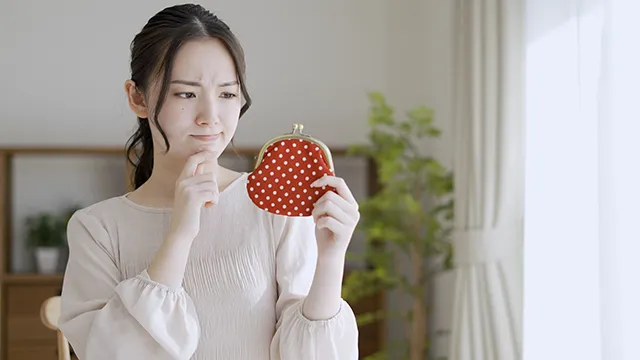 財布を見て渋い顔をる女性