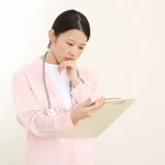 カルテを見て悩む看護師
