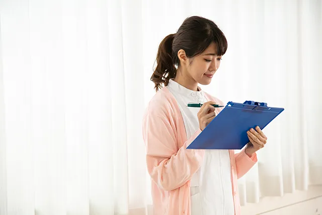 カルテを見る看護師