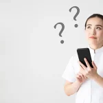 スマホを持って疑問を解決する看護師