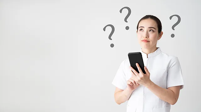 スマホを持って疑問を解決する看護師