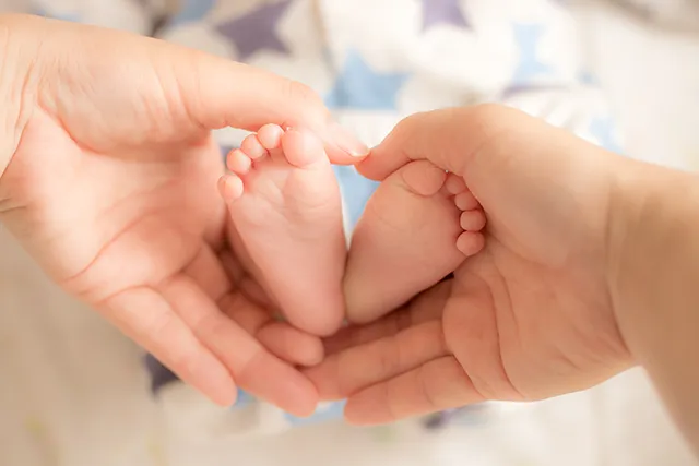赤ちゃんの足と大人の手
