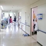 病院の廊下の奥にいる看護師